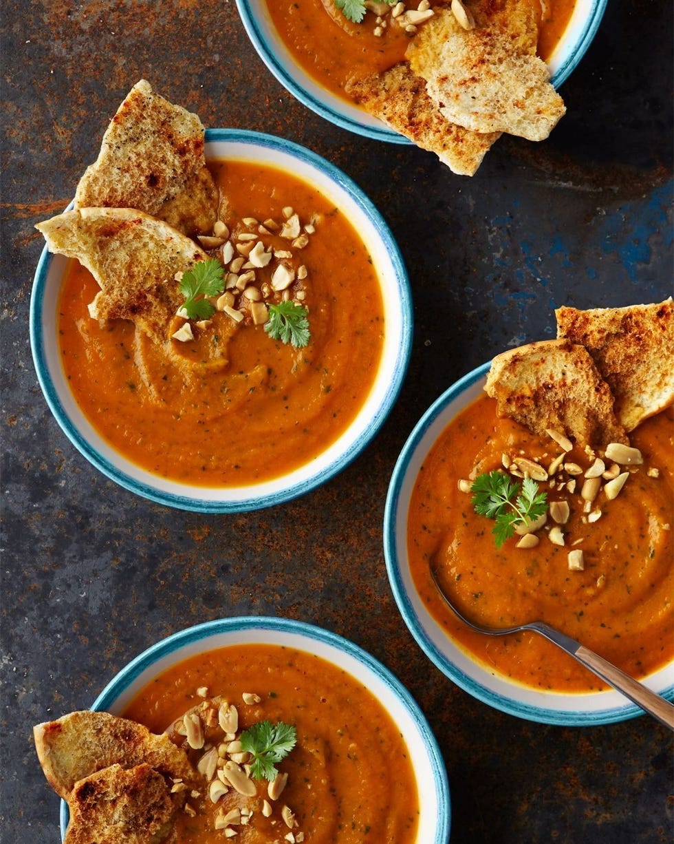 slow cooker sweet potato and peanut puree served in bowls and topped with a sprig of cilantro and chopped peanuts and pita chips