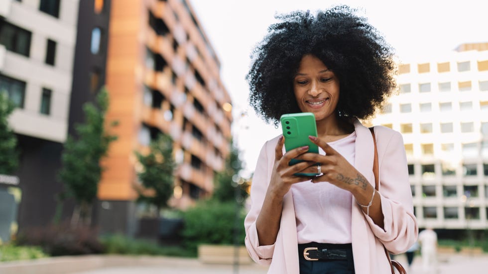 woman using a smartphone outdoors in an urban setting
