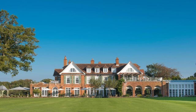 a large brick building with a lawn in front of it