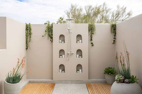 an image of an outdoor shower covered in plants