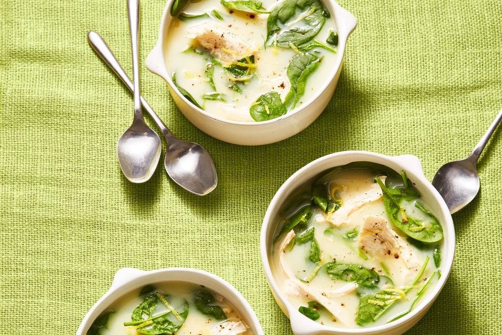 chicken soup with spinach and lemon in white bowls