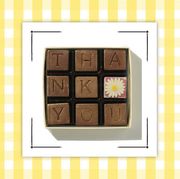 box of chocolates that spell out thank you and plaque with writing on it