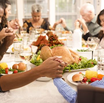thanksgiving prayer  family holding hands in prayer over thanksgiving dinner table