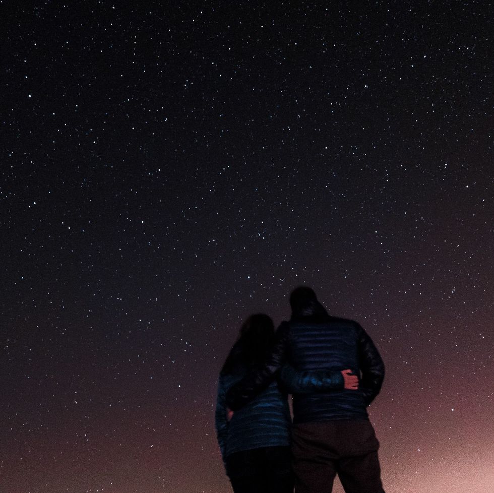 low angle view of couple standing against star field