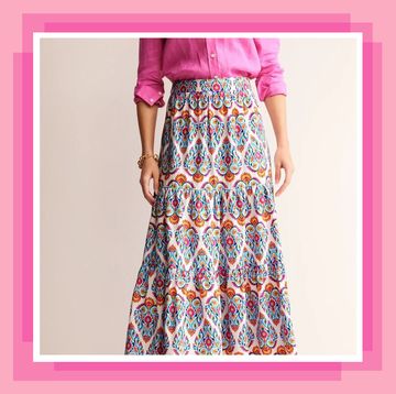 crop of woman in pink shirt and patterned tiered maxi skirt