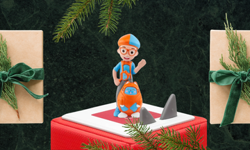 the blippi tonies figure standing on a toniebox against a festive background
