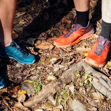 two pairs of hiking shoes on a forest floor covered with leaves and twigs two pairs of hiking shoes on a forest floor covered with leaves and twigs