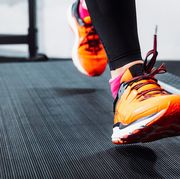 person with orange and pink shoes running on treadmill