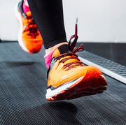 person with orange and pink shoes running on treadmill