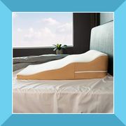 woman leaning against a wedge pillow reading a book, and a wedge pillow place on a bed