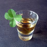 whiskey in shot glass with four leaf clover