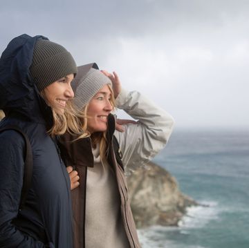 two women looking out at the sea on a windy day