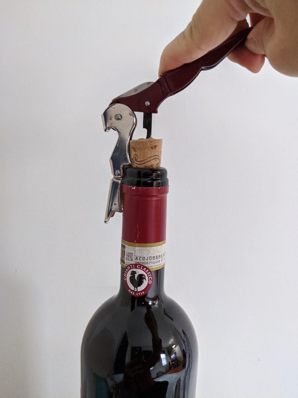 corkscrew being used to remove a cork from a wine bottle