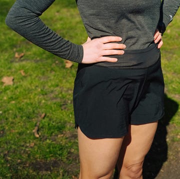 close up of a women's torso in the park wearing black shorts and a grey long sleeve top close up of a women's torso in the park wearing black shorts and a grey long sleeve top