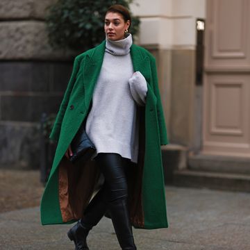 a person wearing a green coat and a scarf