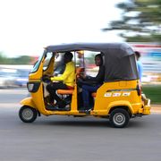 a tuk tuk taxi driver speeds through traffic in bujumbura