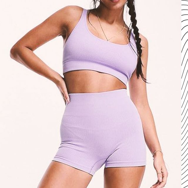 a woman in lilac sports bra and matching shorts that are ideal for hot yoga and a woman in harem pants using a yoga strap
