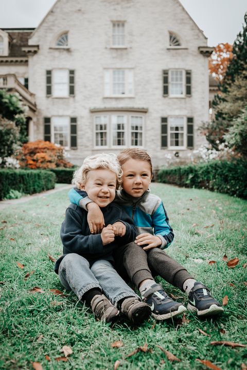 two kids sitting on a lawn