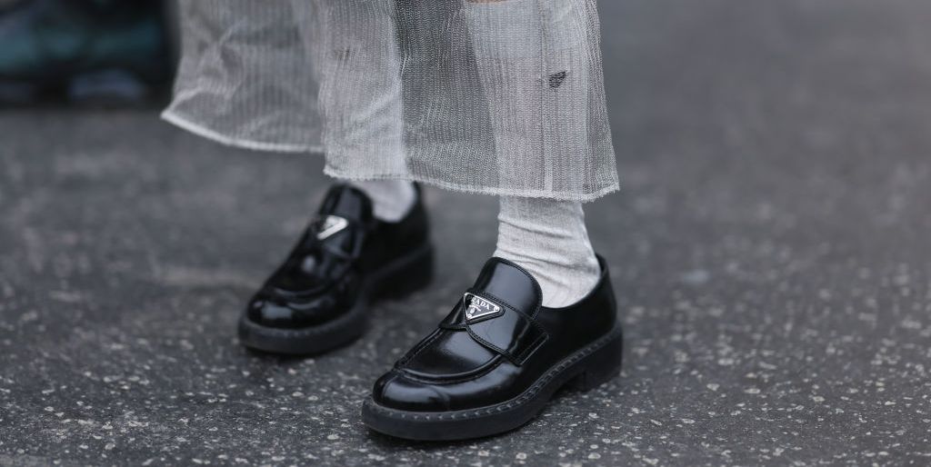 paris, france january 24 a fashion week guest seen wearing a black dress, a prada cleo bag, prada white socks, black leather loafers by prada and dark shades before the stephane rolland show on january 24, 2023 in paris, france photo by jeremy moellergetty images