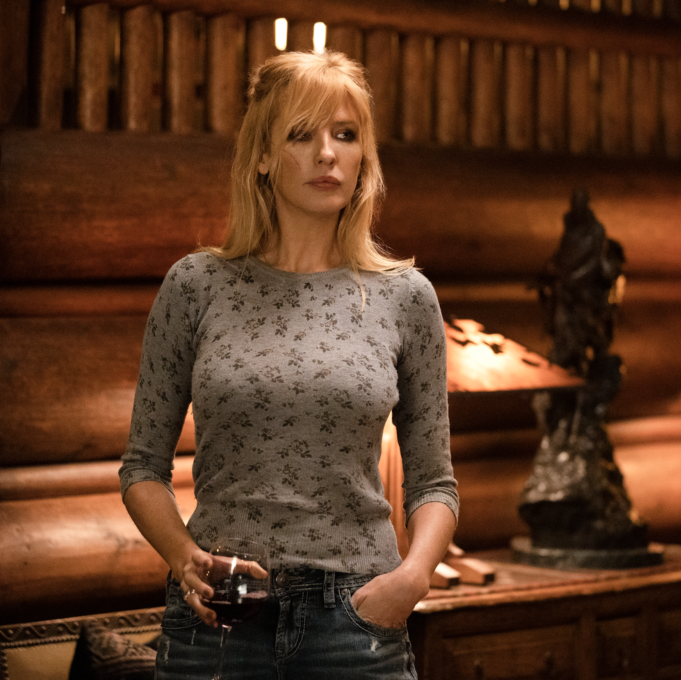 beth dutton costumes, woman holding a wine glass with a casual shirt and jeans on