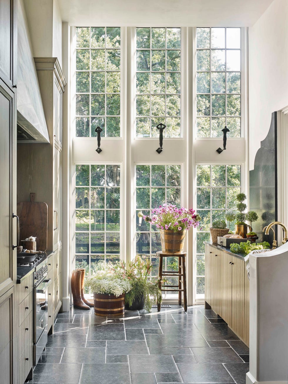 an intimate galley with windows that appear to soar higher than the ceiling, and then bypassed conventional upper cabinetry to avoid making the small kitchen feel boxed in