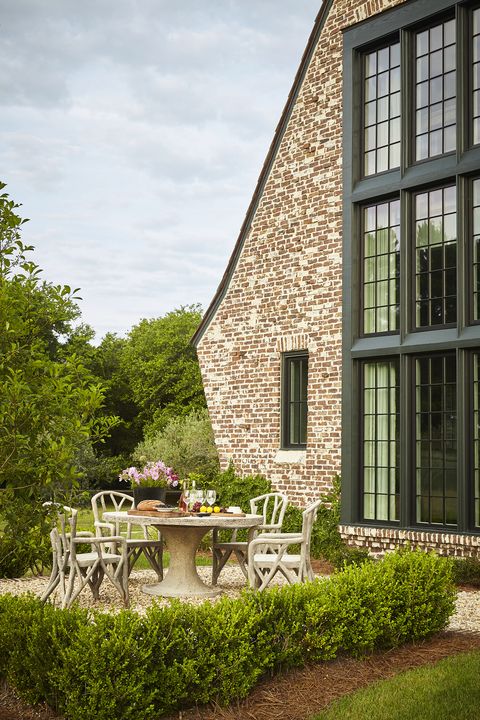 the hues of aged clinker bricks nod to the low country vernacular and there are faux bois table and chairs for dining