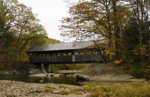 fall foliage bethel, maine, newry covered bridge with river and fall foliage