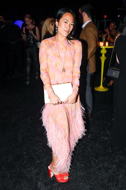 beverly nguyen wears a pink and orange dress with feathers at a lunar new years party