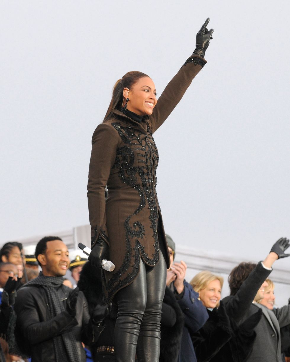 beyonce pointing toward the air with her left hand during a musical performance