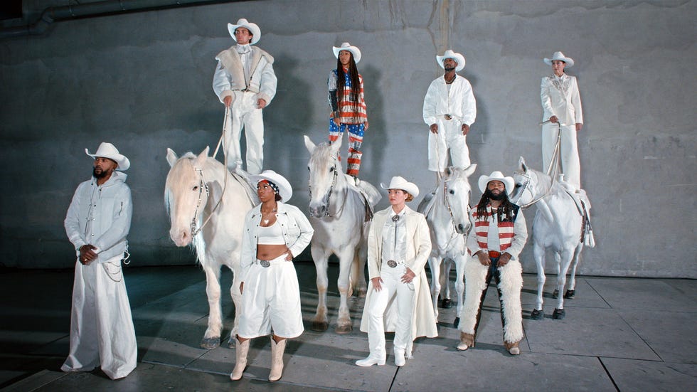 group of individuals dressed in westernstyle outfits with multiple white horses