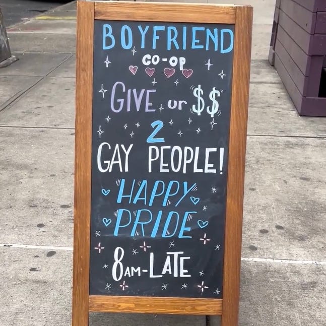 a chalkboard sign displaying a supportive message for pride