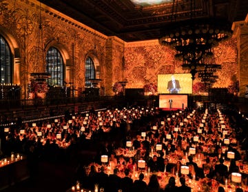 a large group of people in a room with a stage and a screen