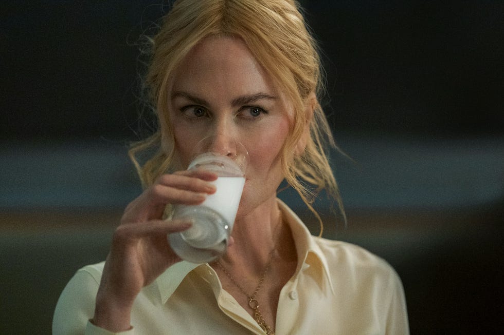 A person holding a cup dressed in a lightcolored shirt
