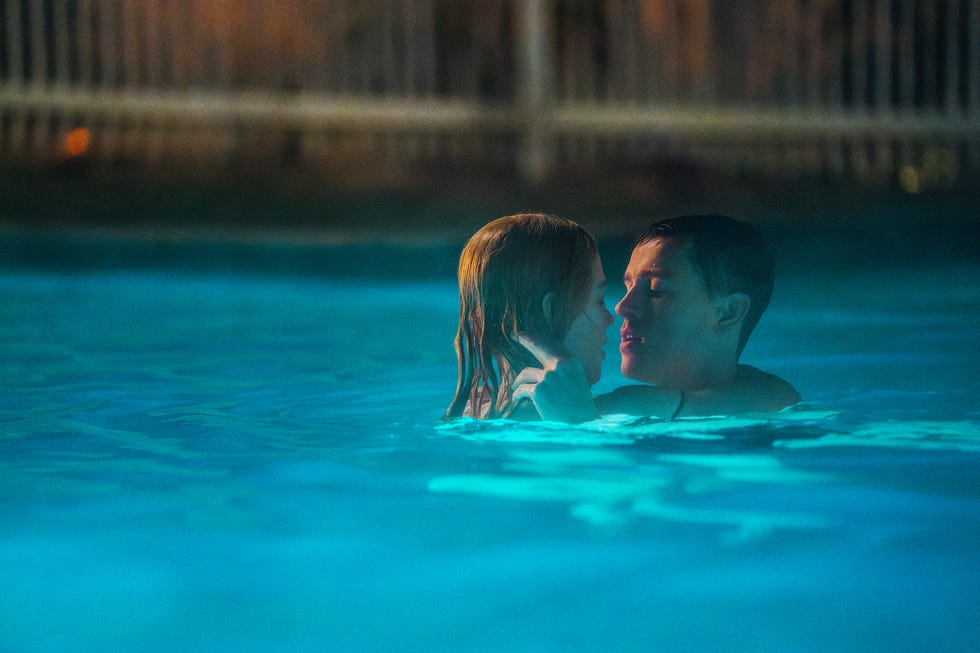 two individuals in a swimming pool engaging closely