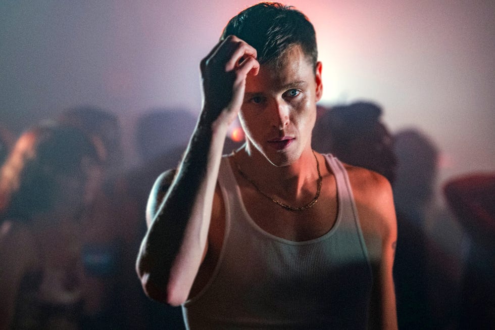 individual dancing at a party in a dimly lit environment with colorful lighting