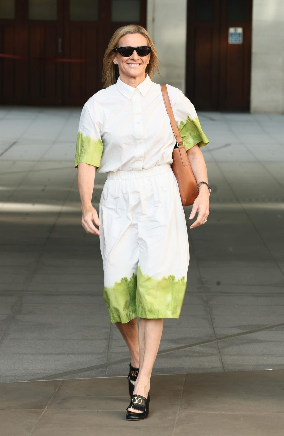 *exclusive* gabby logan looked stunning after being announced as the replacement for garry lineker. gabby was spotted stepping out at the bbc radio 2 studio, wearing a chic matching skirt and top, complemented by elegant valentino heels