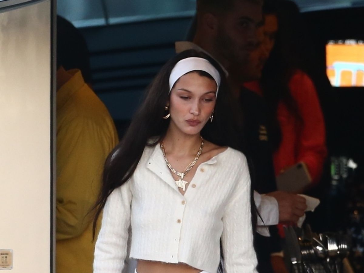 Bella Hadid wears a gingham blazer and a sweater as she rides a