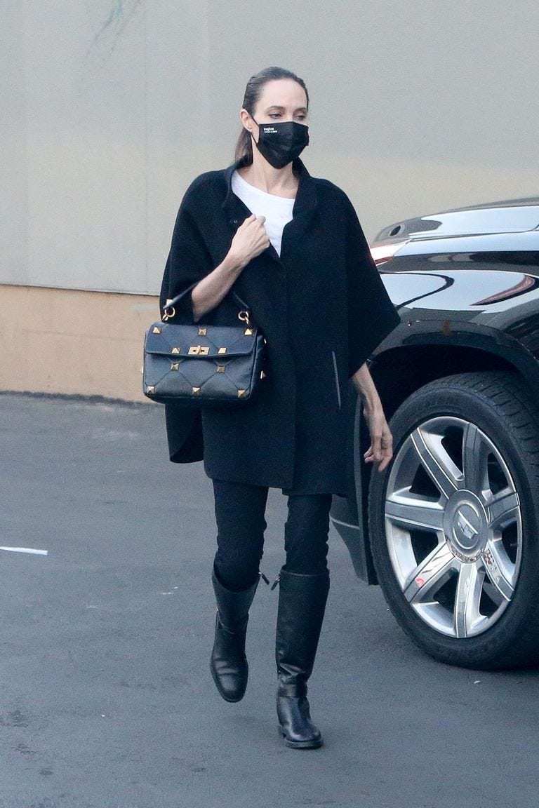 Angelina Jolie in black blazer with black tall boots, black