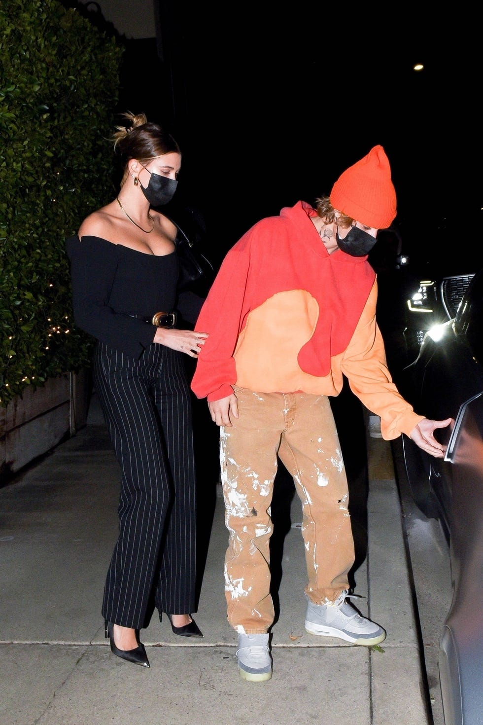 hailey holds onto justin's arm as he reaches for the car door handle