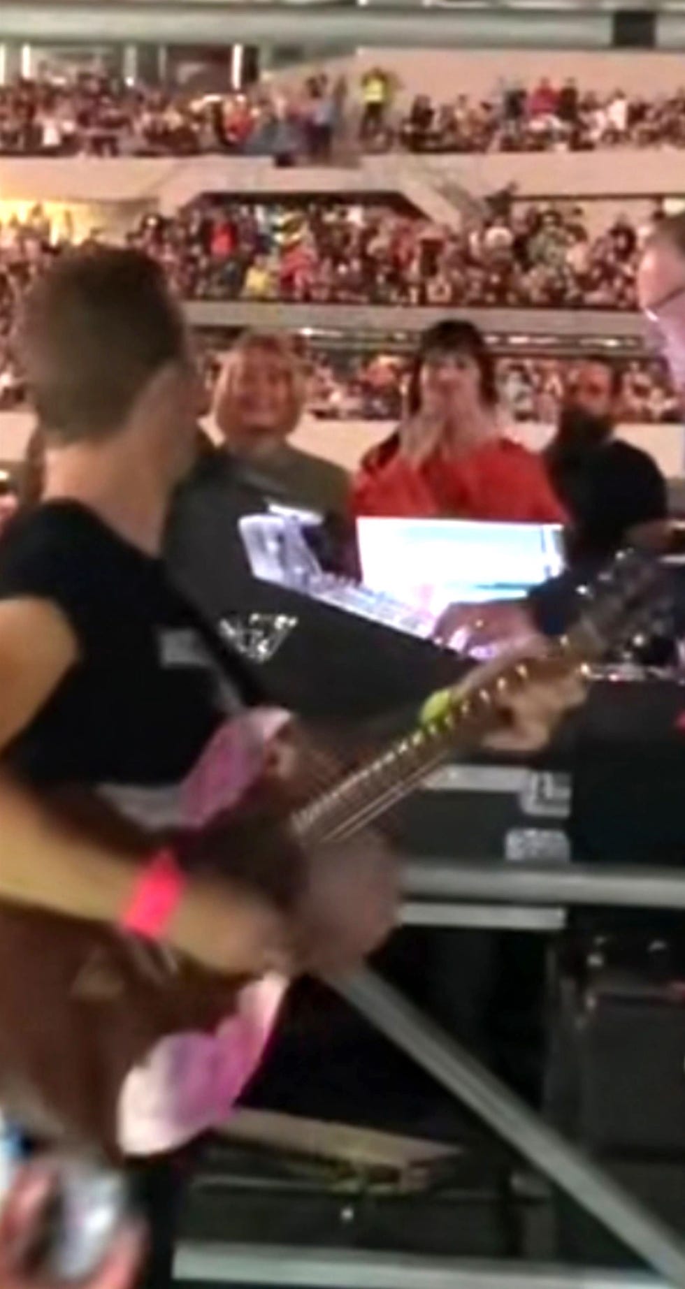 a person playing a guitar in front of a crowd