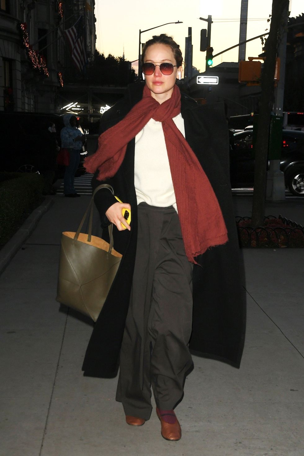 a woman in a red scarf and sunglasses holding a shopping bag