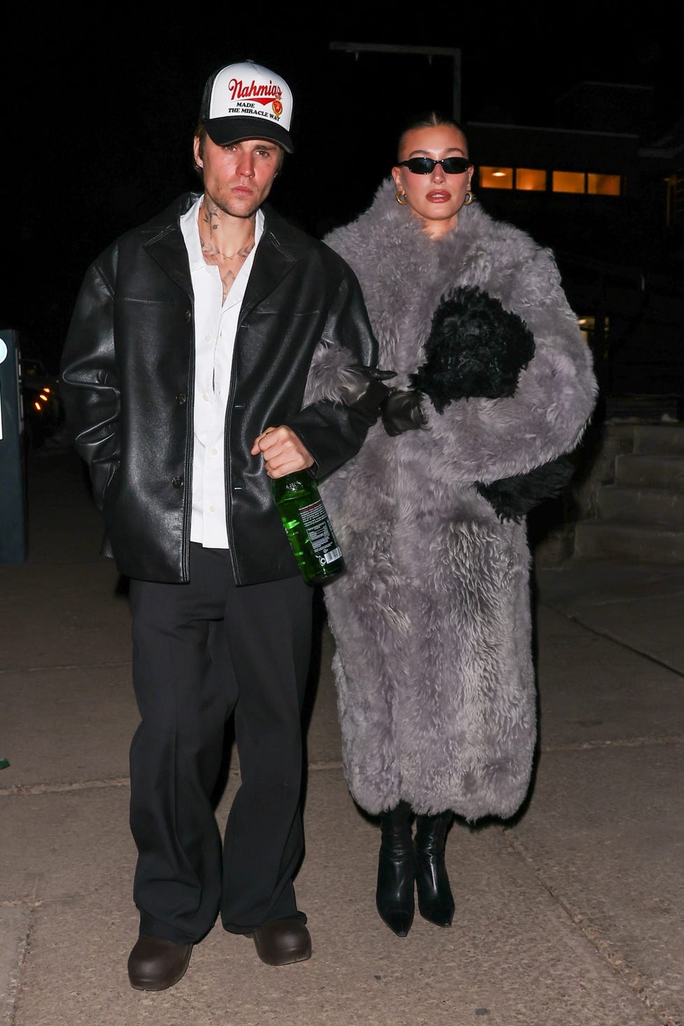 hailey and justin walk arm in arm on sidewalk