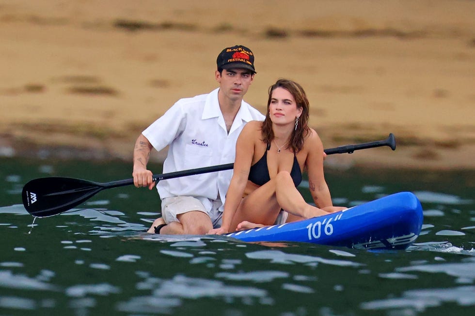 a man and woman on a paddle board in the water