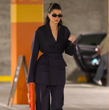 kendall jenner pairs navy suit with an orange bag