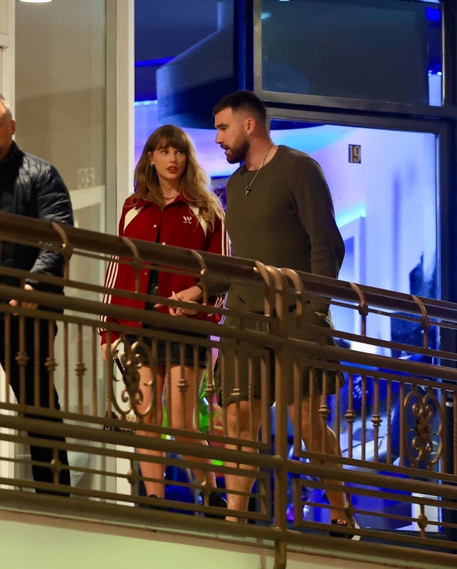 a man and woman standing next to each other and looking at each other