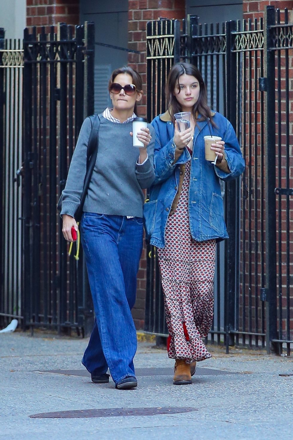 two women walking down a sidewalk