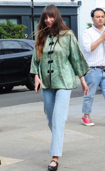 dakota johnson leaves a sugaring spa in london wearing a green silky top and jeans on july 12, 2024