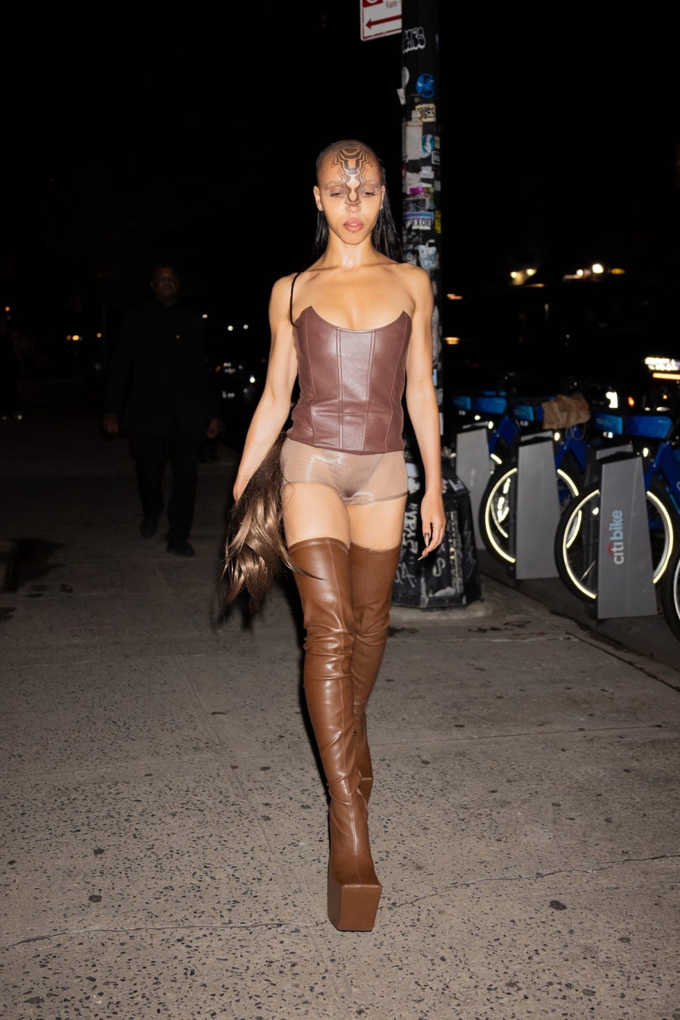 fka twigs wearing a brown leather corset and boots