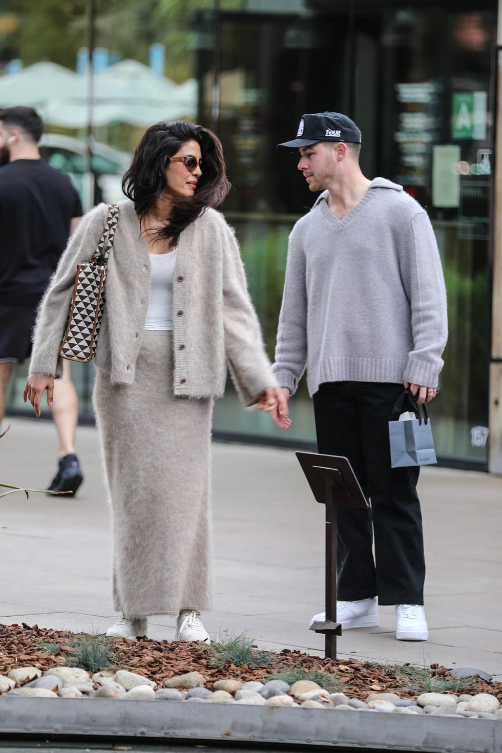 a couple holding hands while walking outdoors