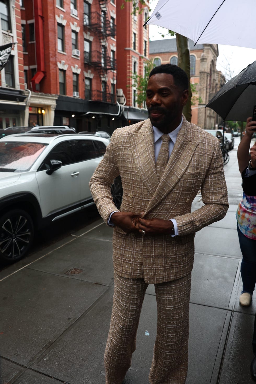 a person in a checkered beige suit on a city street